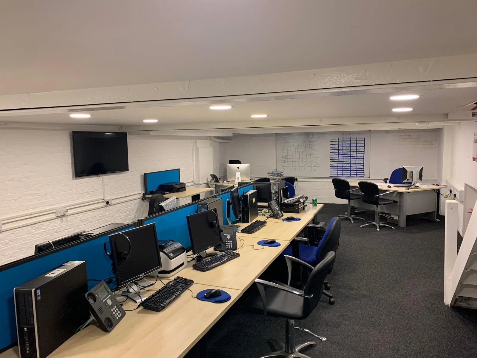 The REST UK office: a row of desks, screens and a planning board